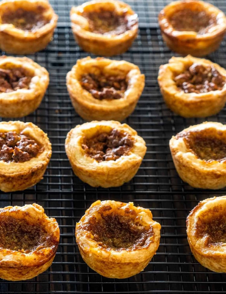 freshly baked butter tarts cooling on a rack.