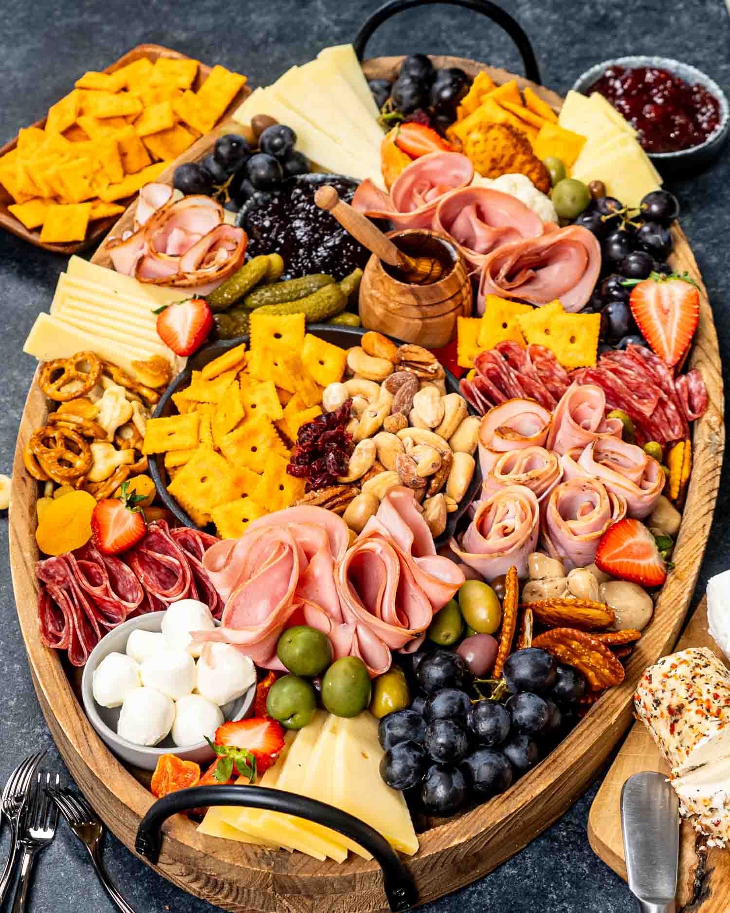 a gorgeous charcuterie board loaded with cured meats, pickled vegetables, an assortment of cheeses and crackers.