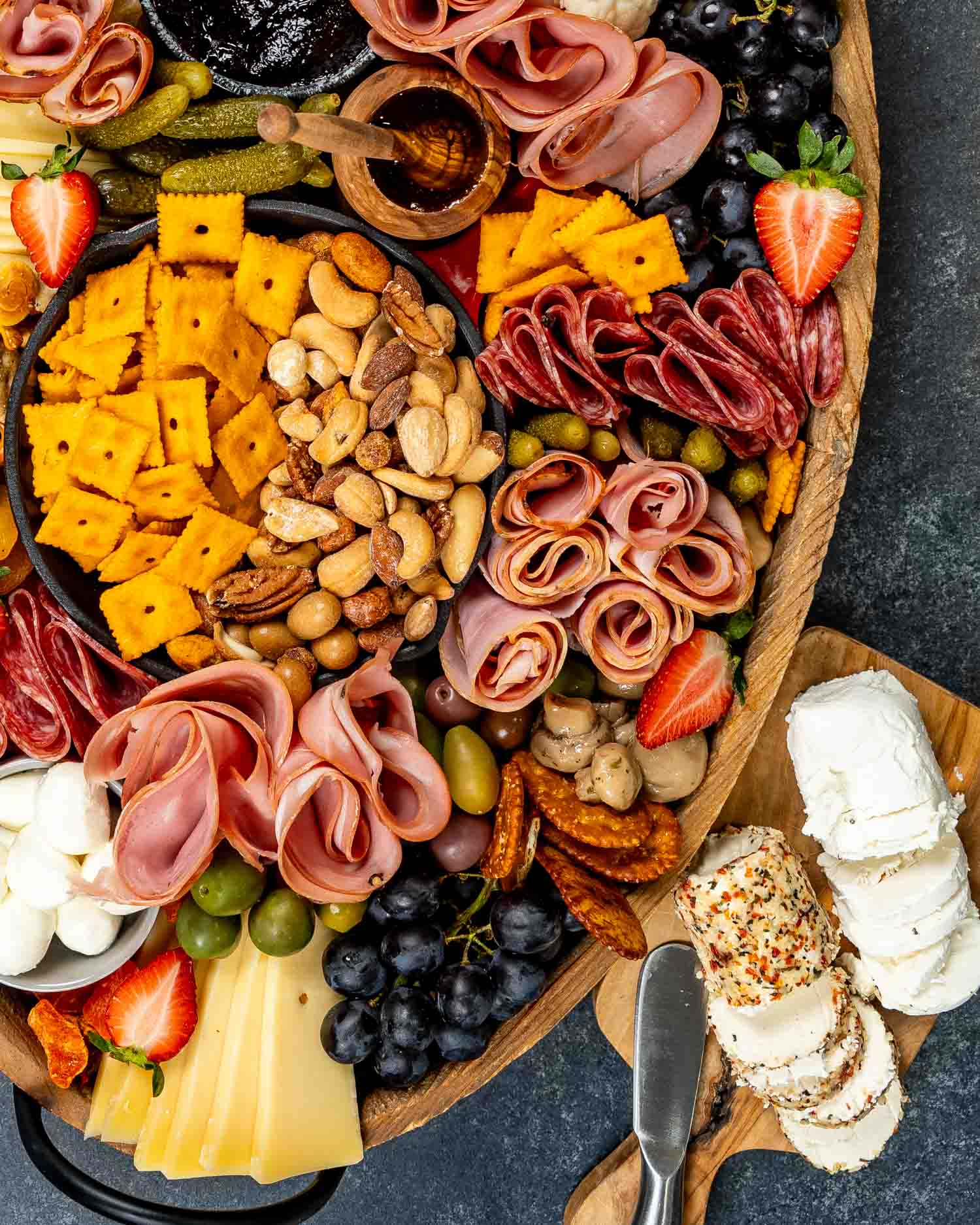 a gorgeous charcuterie board loaded with cured meats, pickled vegetables, an assortment of cheeses and crackers.