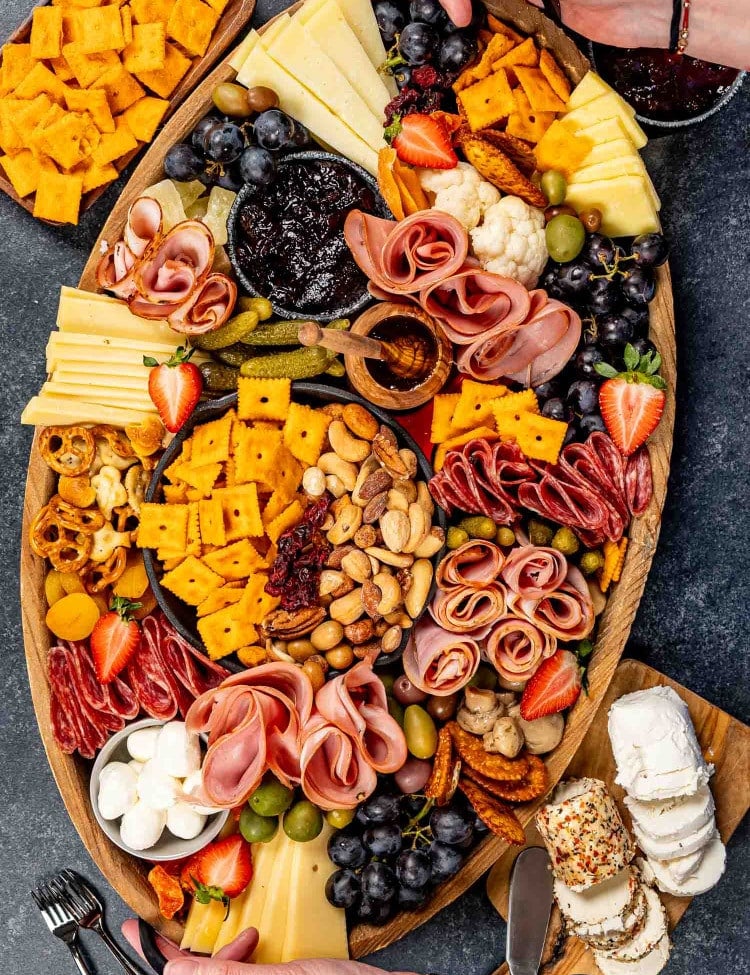 a gorgeous charcuterie board loaded with cured meats, pickled vegetables, an assortment of cheeses and crackers.