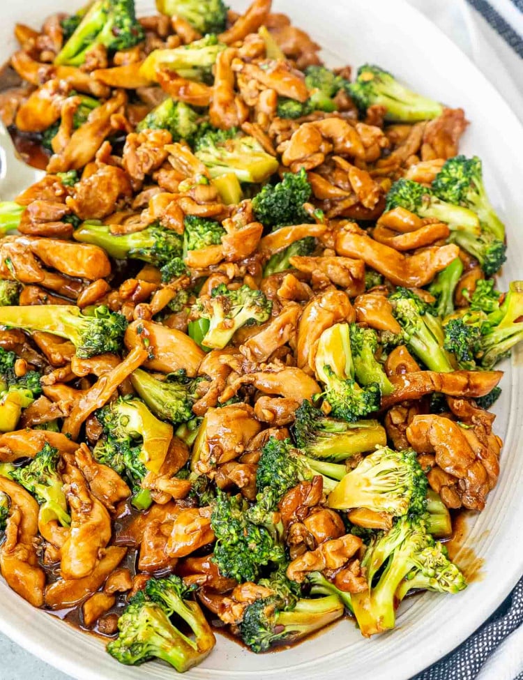 chicken broccoli stir fry on a white platter.