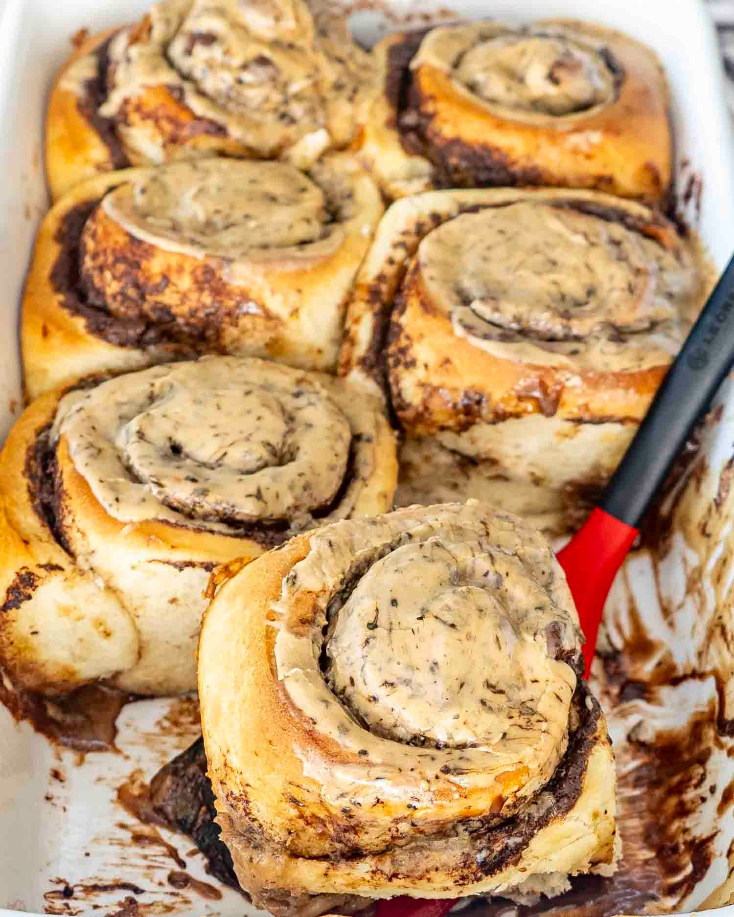 freshly made chocolate espresso rolls in a baking dish with espresso icing.