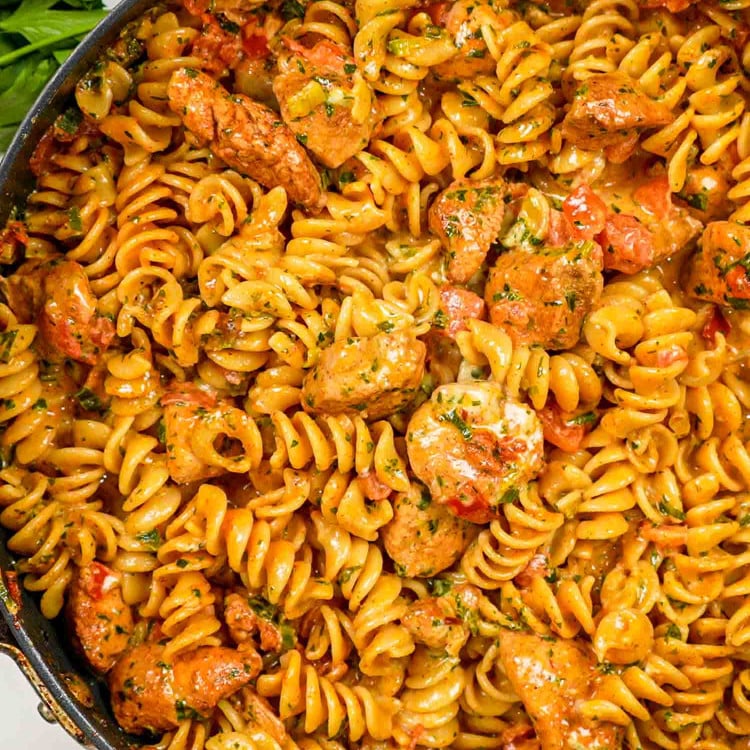 freshly made creamy tomato chicken pasta in a skillet.