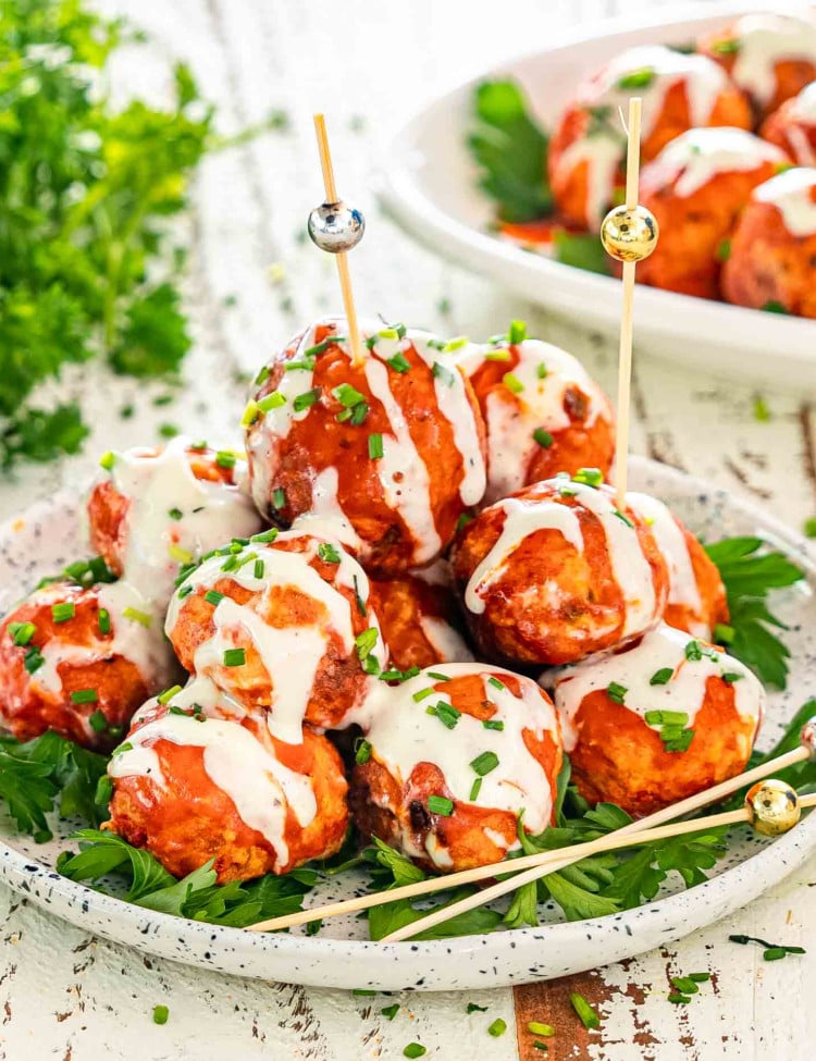 a plate with crockpot buffalo chicken meatballs drizzled with blue cheese dressing.