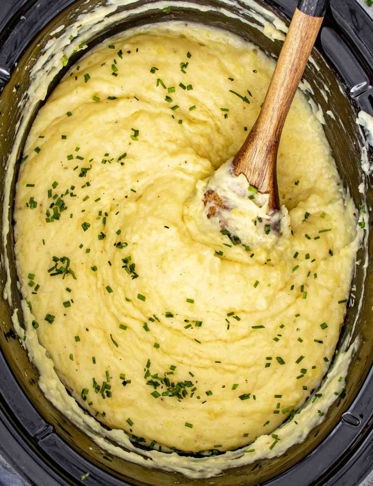 crockpot mashed potatoes garnished with chives.