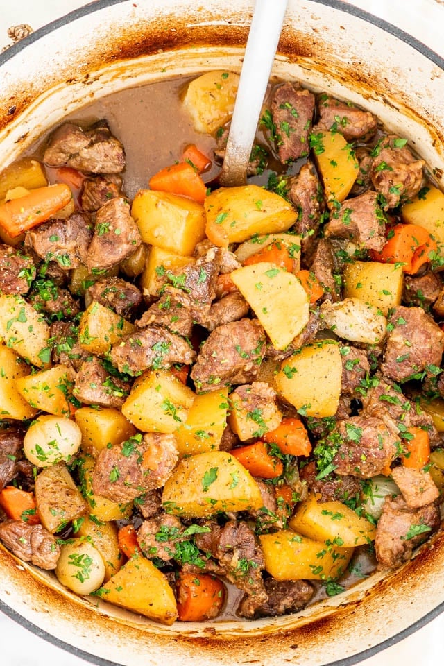 overhead shot of a ladle taking a scoop of irish lamb stew