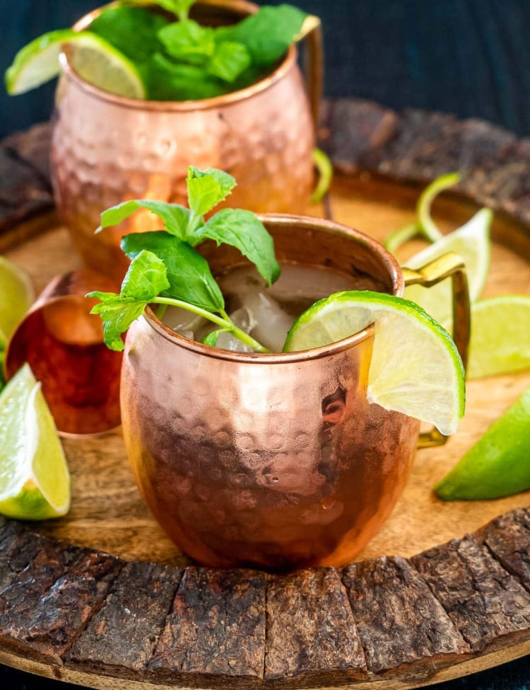 overhead shot of two irish mule cocktails garnished with mint and lime wedges.