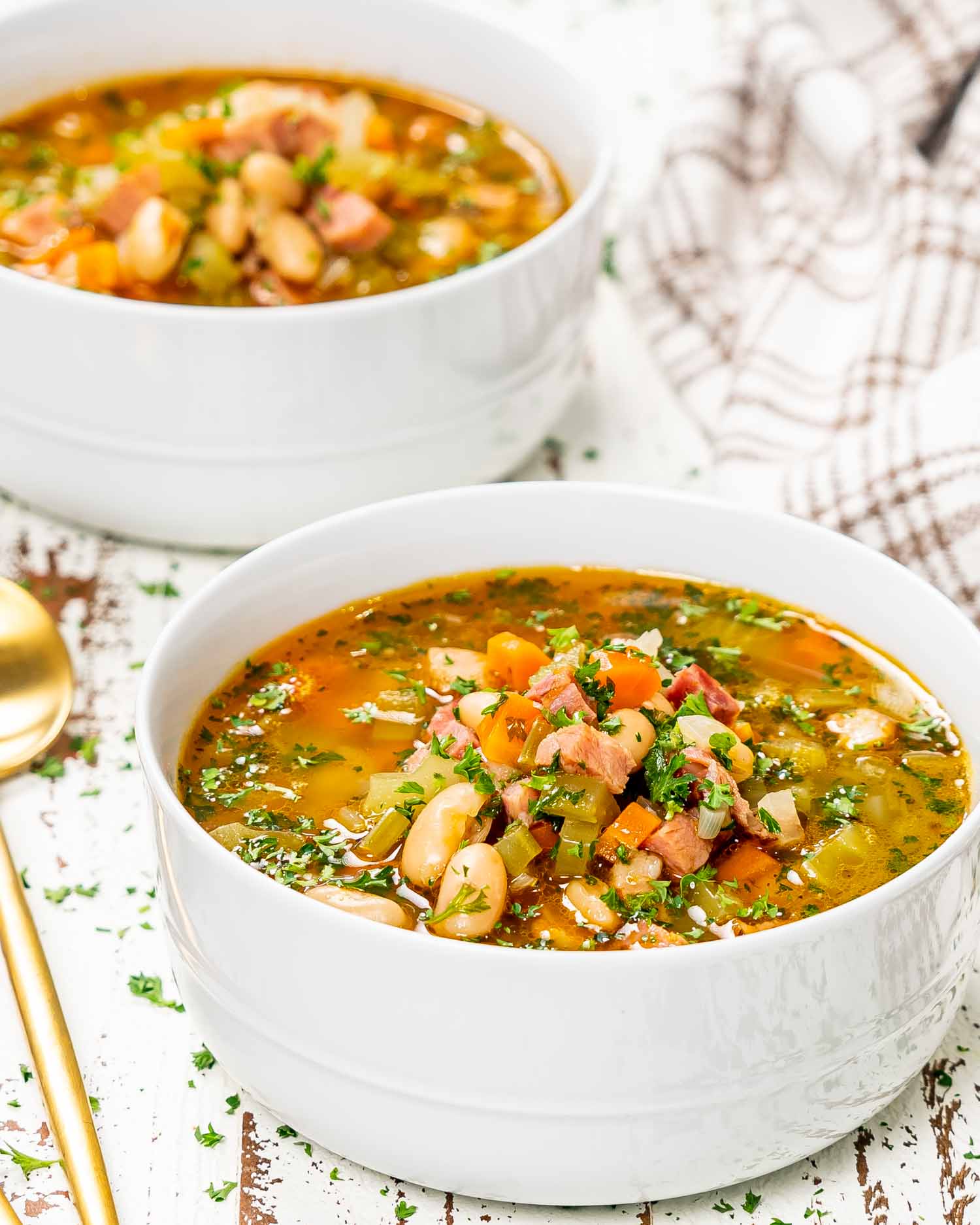 leftover ham and bean soup in a white bowl.