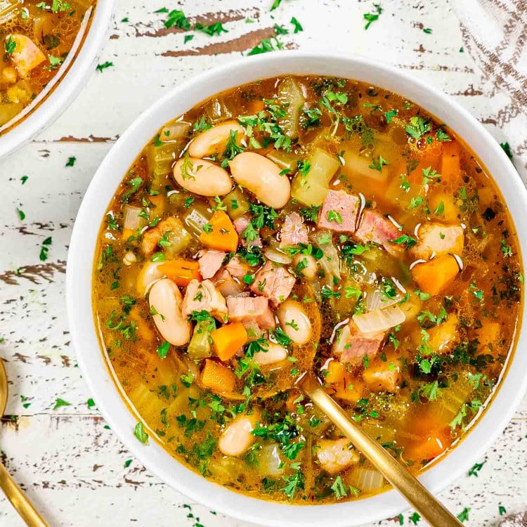 leftover ham and bean soup in a white bowl.