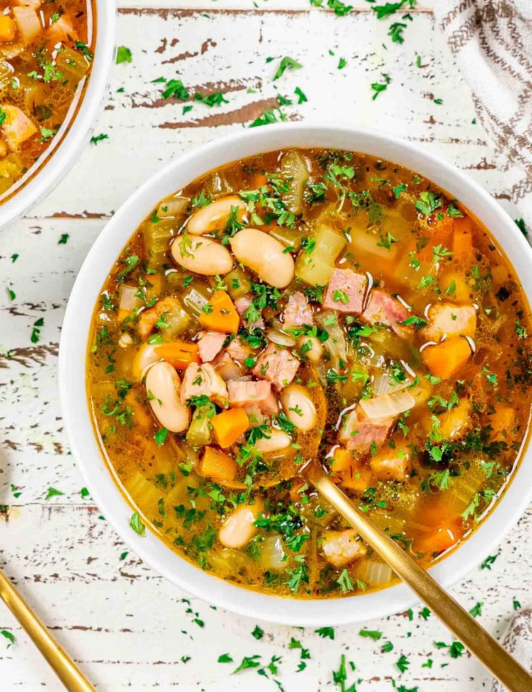 leftover ham and bean soup in a white bowl.