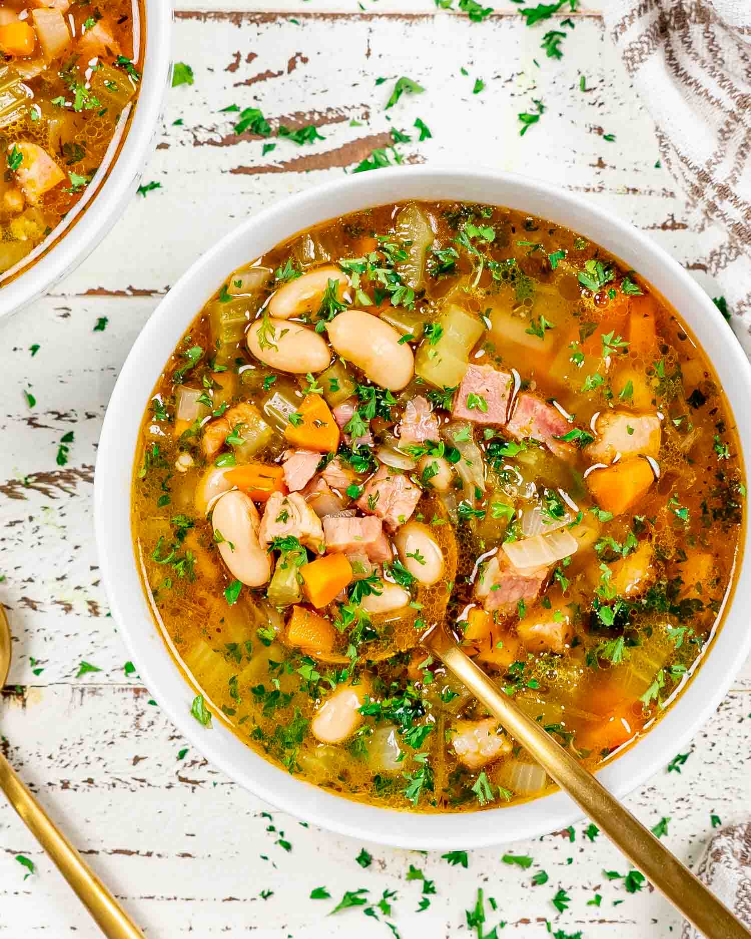 leftover ham and bean soup in a white bowl.