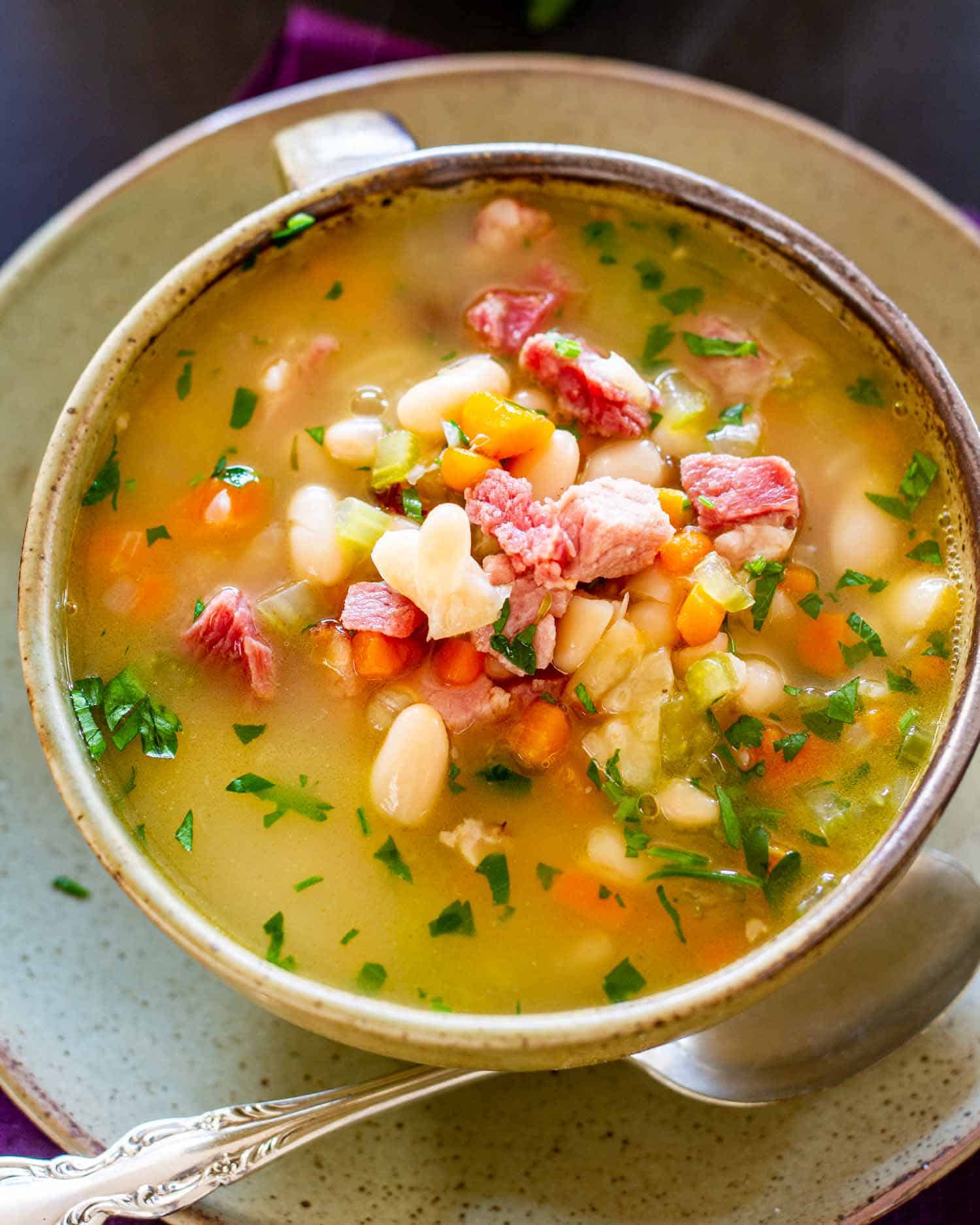 leftover ham and bean soup in a green/beige bowl.