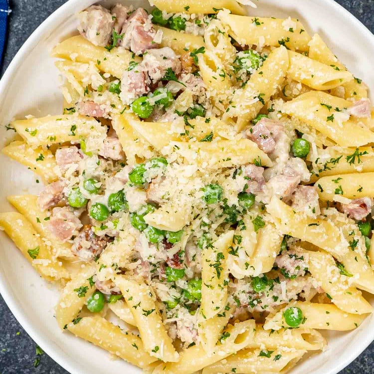 a serving of leftover ham and cheese penne in a white bowl.