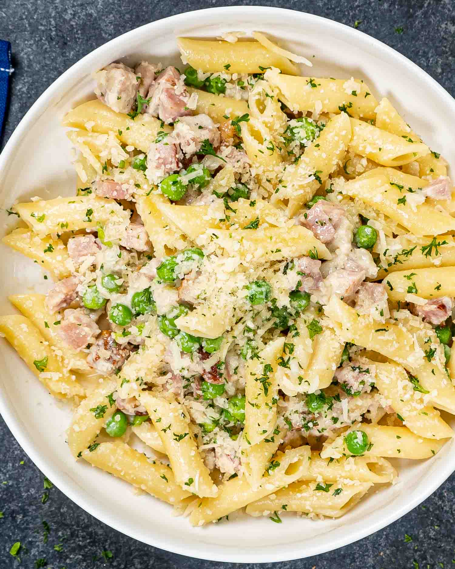 a serving of leftover ham and cheese penne in a white bowl.