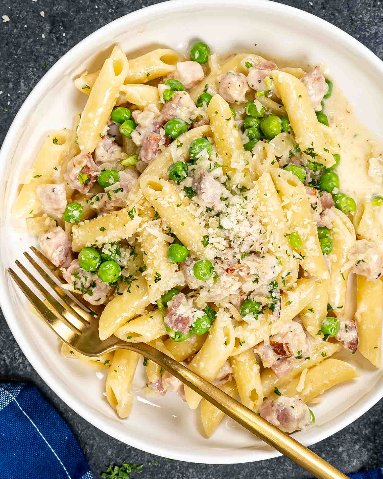 a serving of leftover ham and cheese penne in a white bowl.