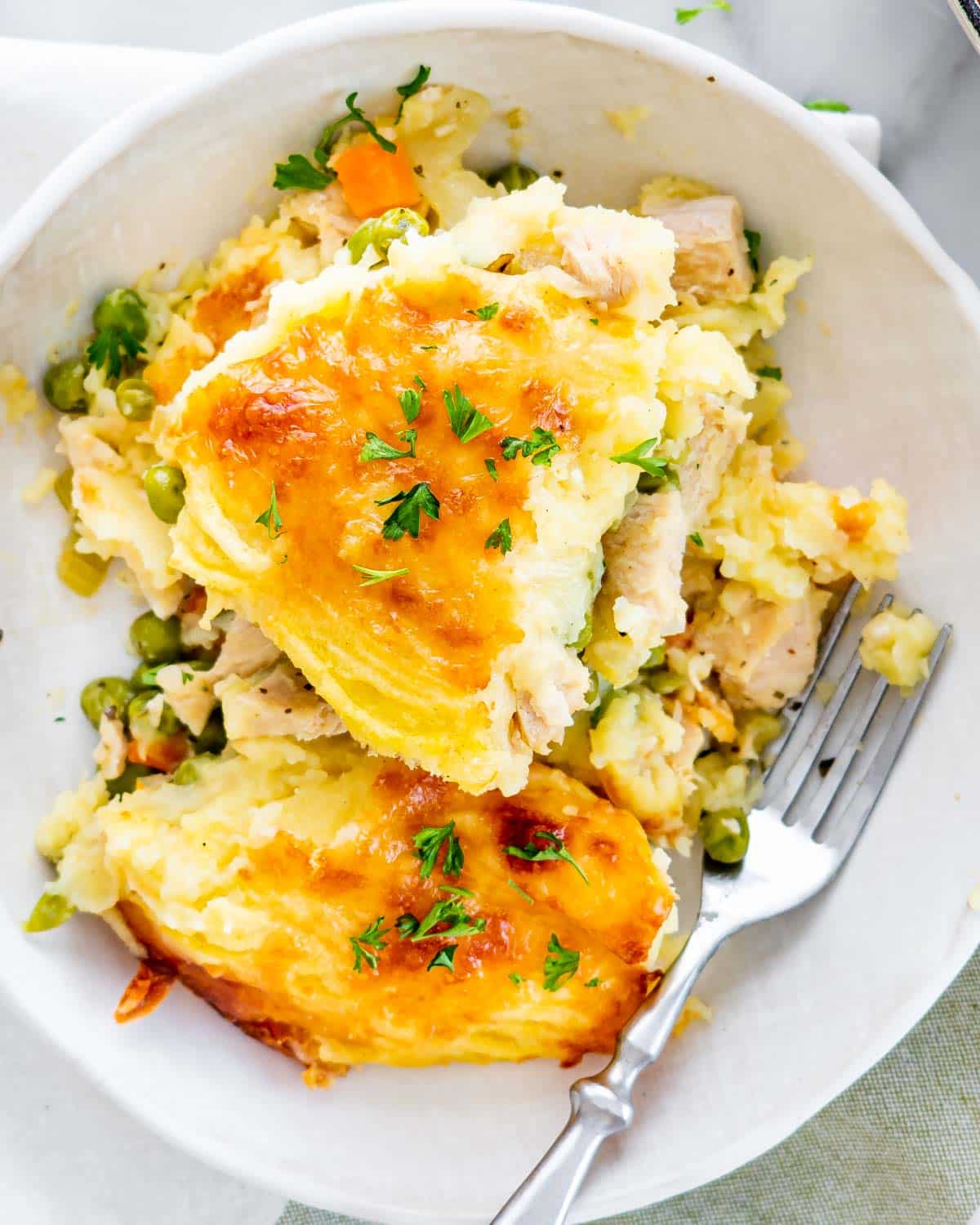 leftover turkey shepherd's pie in a white plate with a fork.