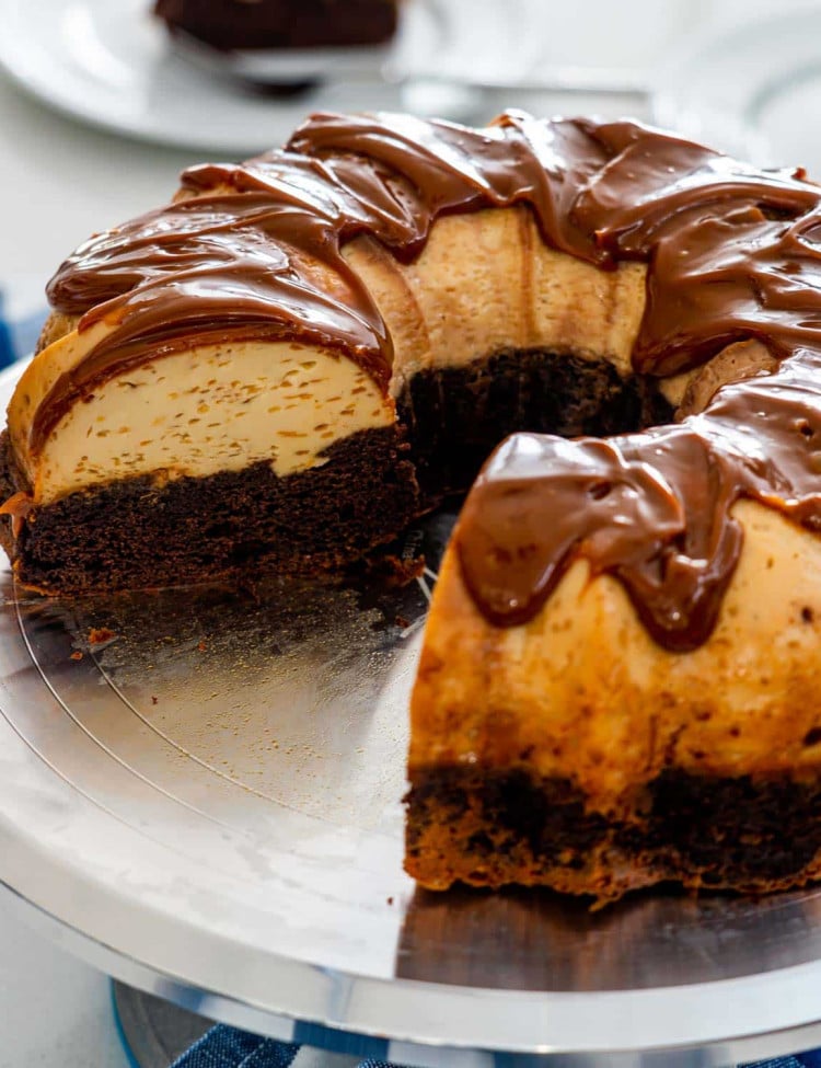 a magic flan cake on a cake platter with some slices cut out of it.