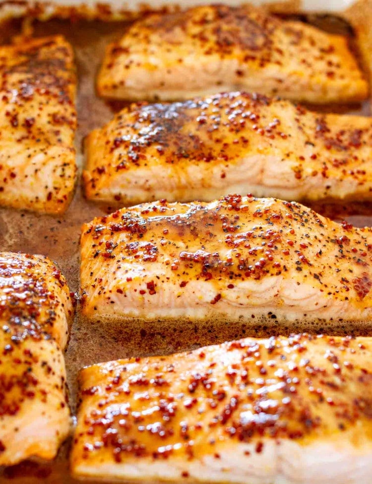 baked maple mustard glazed salmon in a white baking dish.