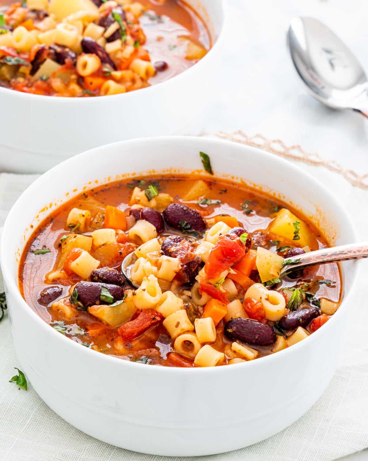 minestrone soup in a bowl with a spoon