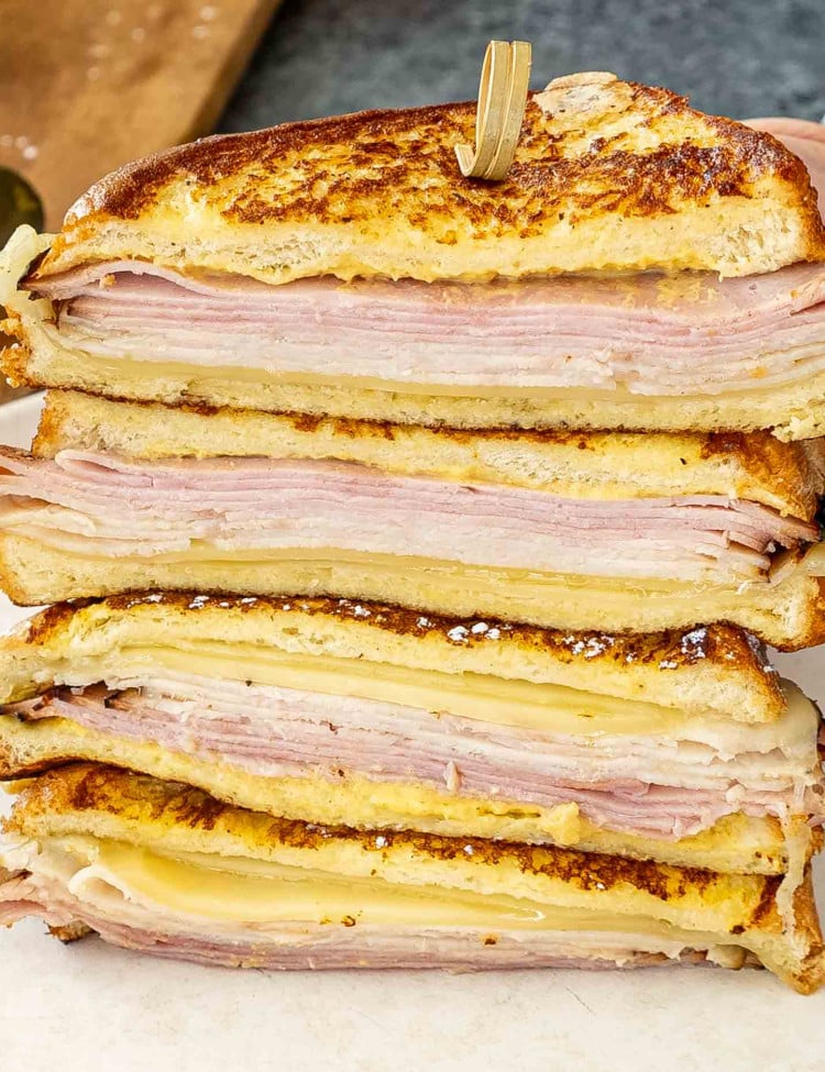 a monte cristo sandwich cut in half on a cutting board.