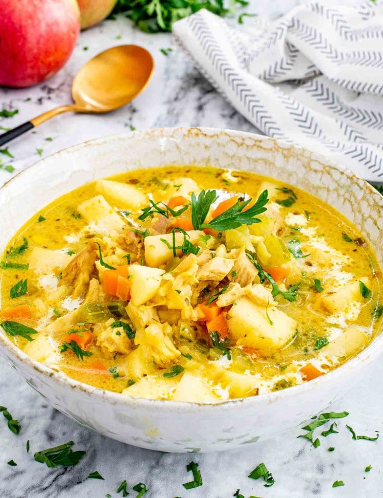 mulligatawny soup in a bowl garnished with parsley.