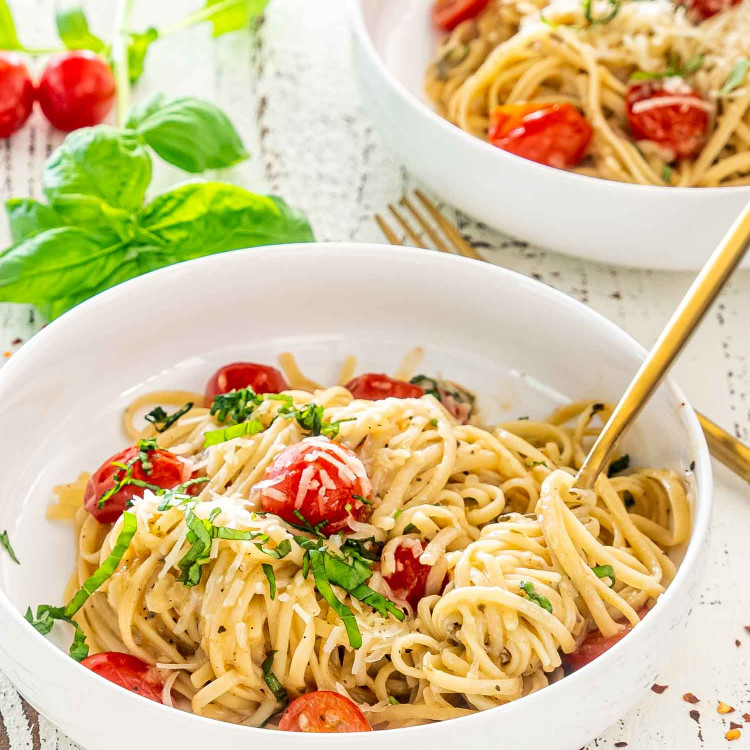 freshly made one pot pasta in white bowls garnished with basil.