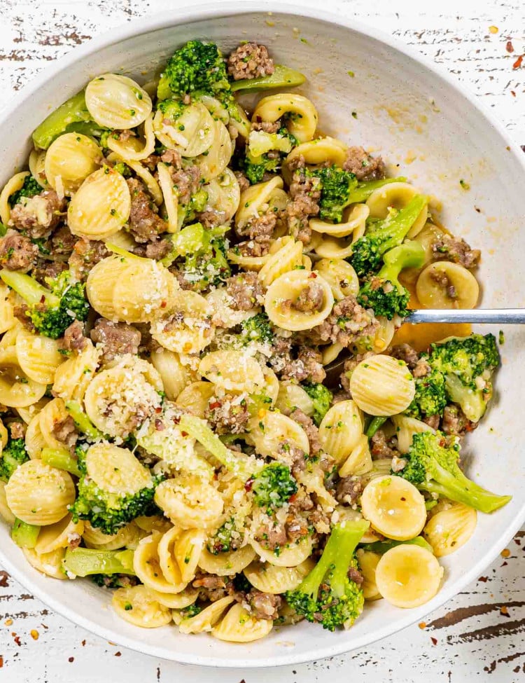 orecchiette with sausage and broccoli in a white serving bowl.