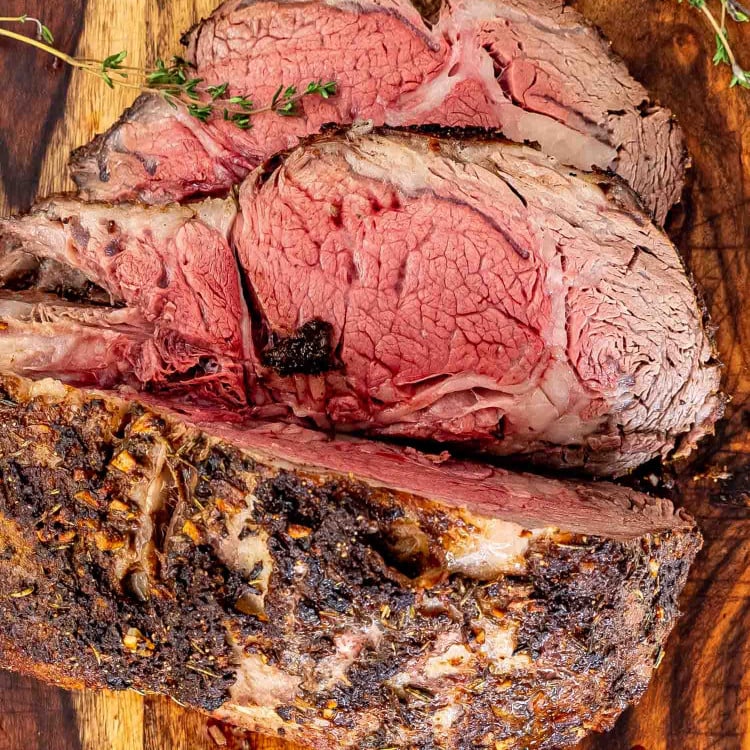 a sliced prime rib roast on a cutting board.