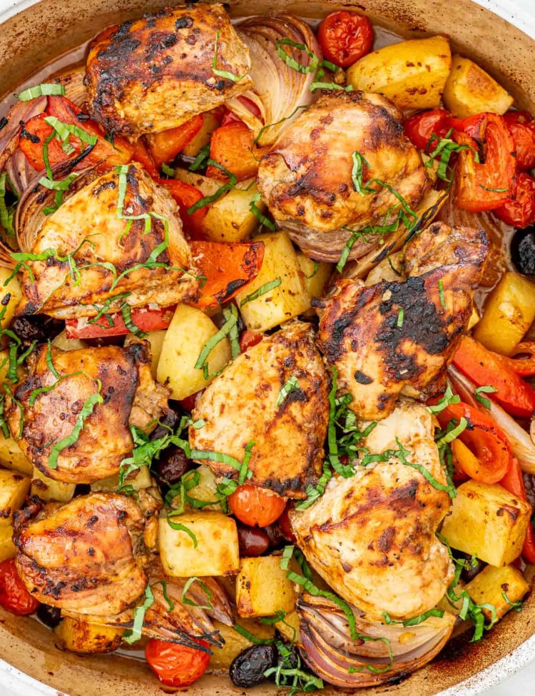 fresh out of the oven, roasted chicken and vegetables in a baking dish.