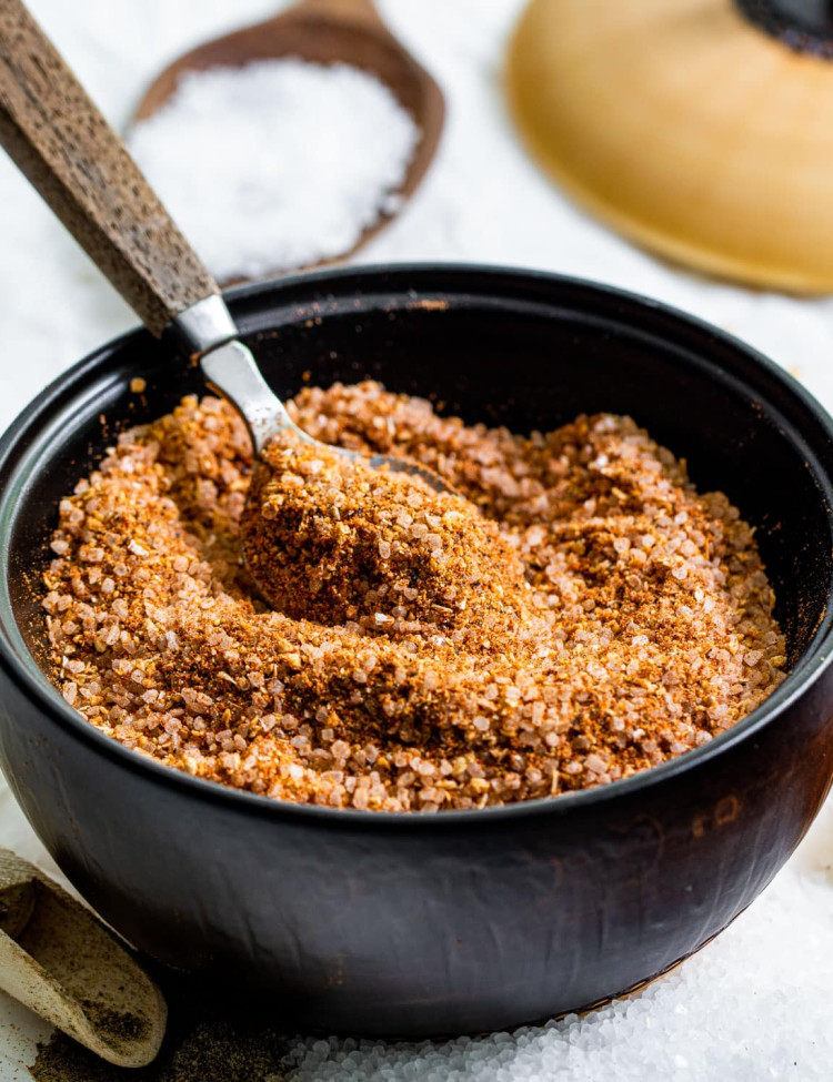 a little black bowl filled with homemade seasoning salt with a spoon in it