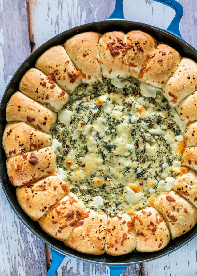 overhead shot of skillet pull apart bread with spinach and artichoke dip