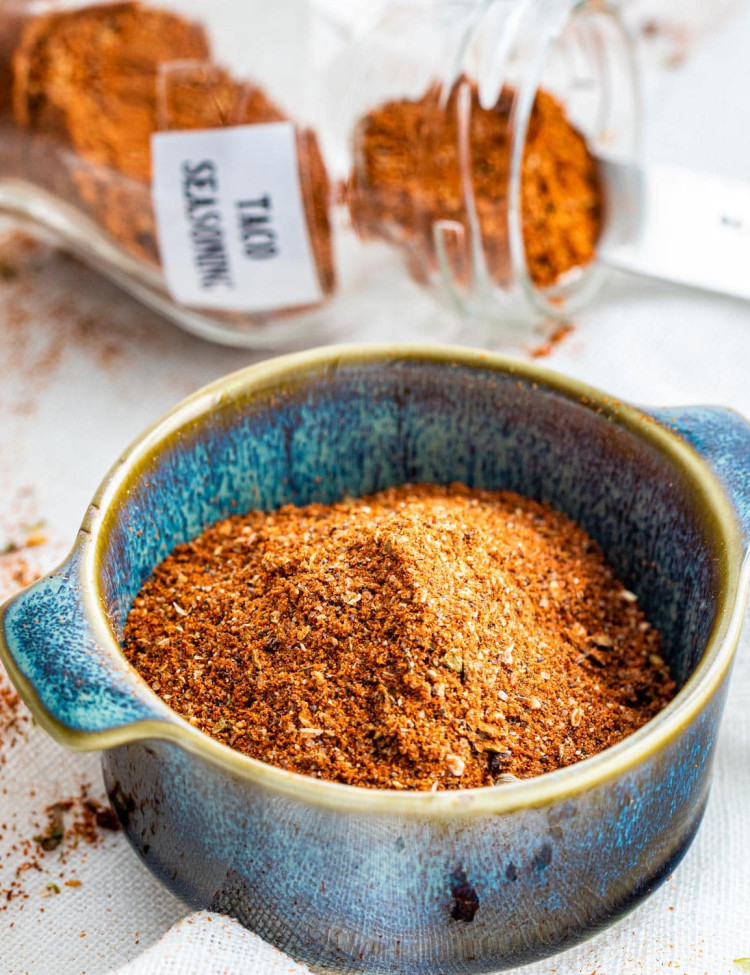 homemade taco seasoning mix in a blue bowl with a jar in the back