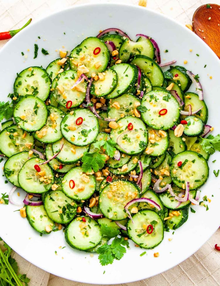 overhead shot of thai cucumber salad freshly made in a white plate