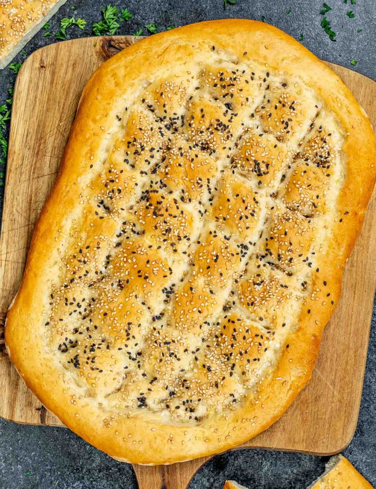 a freshly bread turkish bread on a cutting board.